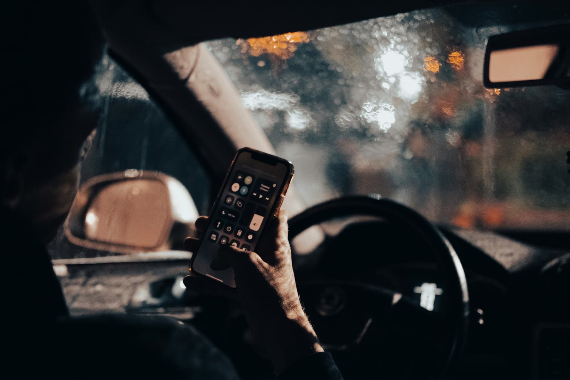 Person holding and using a smartphone inside a car
