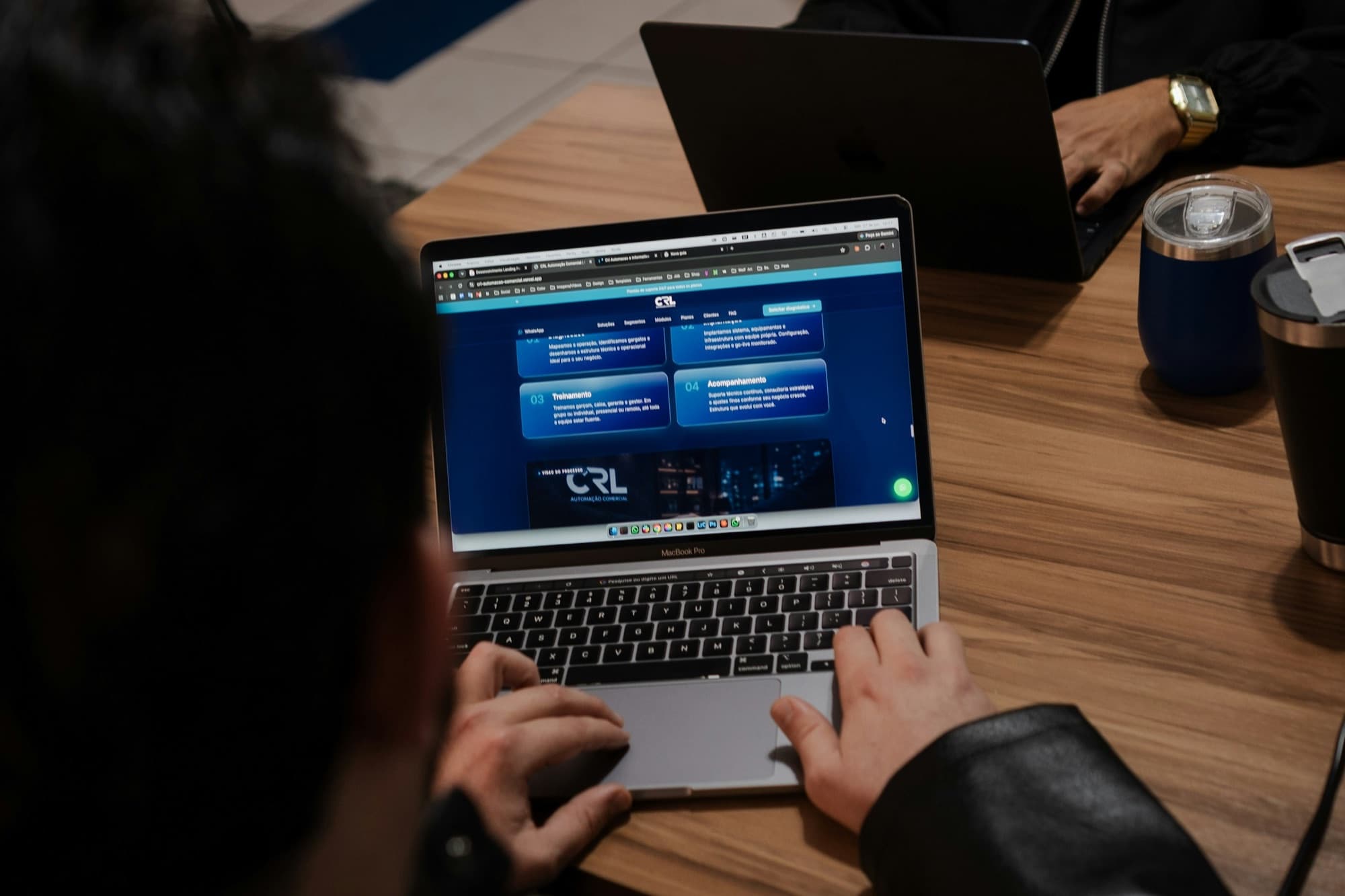 Hands using a laptop displaying an active website interface